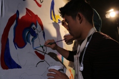 Senior Cody Kurahara paints during the assembly that took place during 3rd and 4th period. (Photo by Alex Ng)